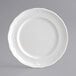 A close-up of an Acopa Condesa pearl white porcelain plate with a decorative edge.