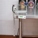 A metal table with an Edlund stainless steel commercial can opener on it.