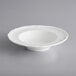 An Acopa Condesa white porcelain bowl with a scalloped edge.