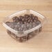 A Genpak clear plastic container filled with chocolate balls.