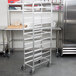 A Winholt aluminum platter rack with wheels in a kitchen.