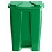 A green plastic Lavex step-on trash can with a lid.