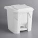 A white plastic rectangular step-on trash can with a lid.