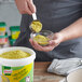 A person pouring yellow Knorr Beef Bouillon powder into a bowl of food.