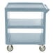 A slate blue Cambro three shelf service cart with wheels.