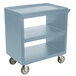 A blue plastic Cambro service cart with three shelves and wheels.