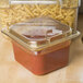 A Carlisle amber plastic food pan filled with pasta and sauce on a hotel buffet counter.
