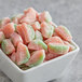 A white bowl filled with close-up pink and green Sour Patch Kids.