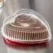 A Durable Packaging heart shaped foil bake pan with a clear plastic lid on a counter.