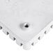 A close-up of a white plastic push block with a screw on top.