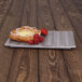 A pastry with cream and strawberries on an Elite Global Solutions brown textured melamine platter.