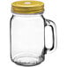 An Acopa clear glass drinking jar with handle and gold metal lid with straw hole.
