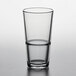 A close-up of a Pasabahce stackable beverage glass half full of water.