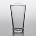 A clear Pasabahce mixing glass with a black rim.
