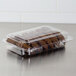 A Dart clear hinged PET plastic container of cookies on a bakery counter.