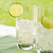 Two glasses of ice with lime wedges on a white background.