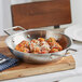 A Vigor stainless steel fry pan filled with meatballs and cheese.