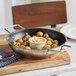 A Vigor stainless steel fry pan with potatoes and sauce in it.
