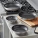 Vigor SS1 Series stainless steel non-stick fry pans with dual handles on a stove top.