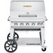 A silver Crown Verity outdoor grill on wheels with a cart.