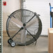A TPI 36" industrial drum fan on a cart in a warehouse.