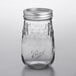 A Ball clear glass flute canning jar with silver metal lid.