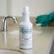 A white bottle of Noble Chemical Non-Valient Toilet Bowl & Restroom Cleaner on a counter.