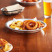 A Baker's Mark aluminum pie pan filled with onion rings on a table.