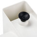 A white plastic suction cup with a black button.