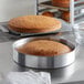 A round brown cake in a Choice aluminum cake pan.