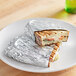 Choice aluminum foil wrapped sandwich on a plate.