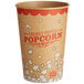 A brown and red Carnival King paper cup with white and red text filled with popcorn.