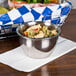 An American Metalcraft stainless steel round sauce cup of pasta on a napkin.