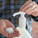 A person using a Noble Chemical plastic foaming soap/sanitizer pump.