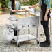 A man and woman outside with food on a Backyard Pro outdoor steam table.