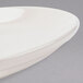 A close up of a Homer Laughlin ivory coupe china plate with a curved edge.