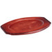 A mahogany oval underliner under a red oval plate.