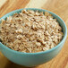 A bowl of Quaker Old Fashioned Rolled Oats on a wood surface.