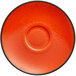 An orange RAK Porcelain saucer with a black border.