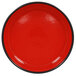 A red porcelain bowl with a white interior and black rim.