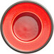 A red porcelain saucer with a black rim.