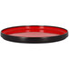 A red rimless round porcelain plate on a table.