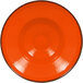 A white RAK Porcelain plate with an orange rim.