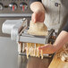 A person using the Choice Prep Electric Stainless Steel Hybrid Pasta Machine to make pasta.