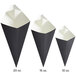 A group of black and white Carnival King cardboard fry cones.