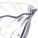 A close up of a clear Cambro Camwear swirl bowl with a wavy edge.