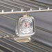 A CDN metal oven thermometer hanging on a rack.