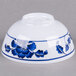 A white Thunder Group melamine rice bowl with blue lotus flowers on it.