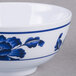 A close up of a white melamine bowl with blue lotus flowers on it.