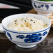 A close up of a Thunder Group Lotus melamine rice bowl filled with rice and black sesame seeds.